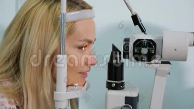 在<strong>眼镜店</strong>用测试装置测量眼睛的女人